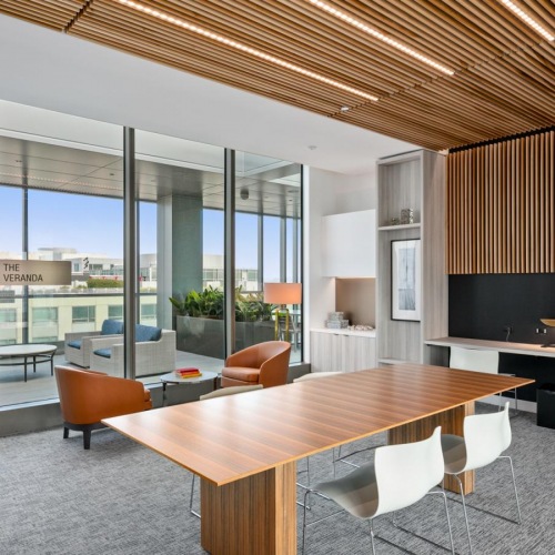 Spacious resident lounge area 2 BR Apartments in Sacramento, CA - 1177 Market at Trinity Place - Lounge Areas with City Views, Artificial Plant, and Wood Benc